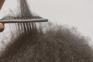 Primo piano di capelli afro durante il districamento con un pettine