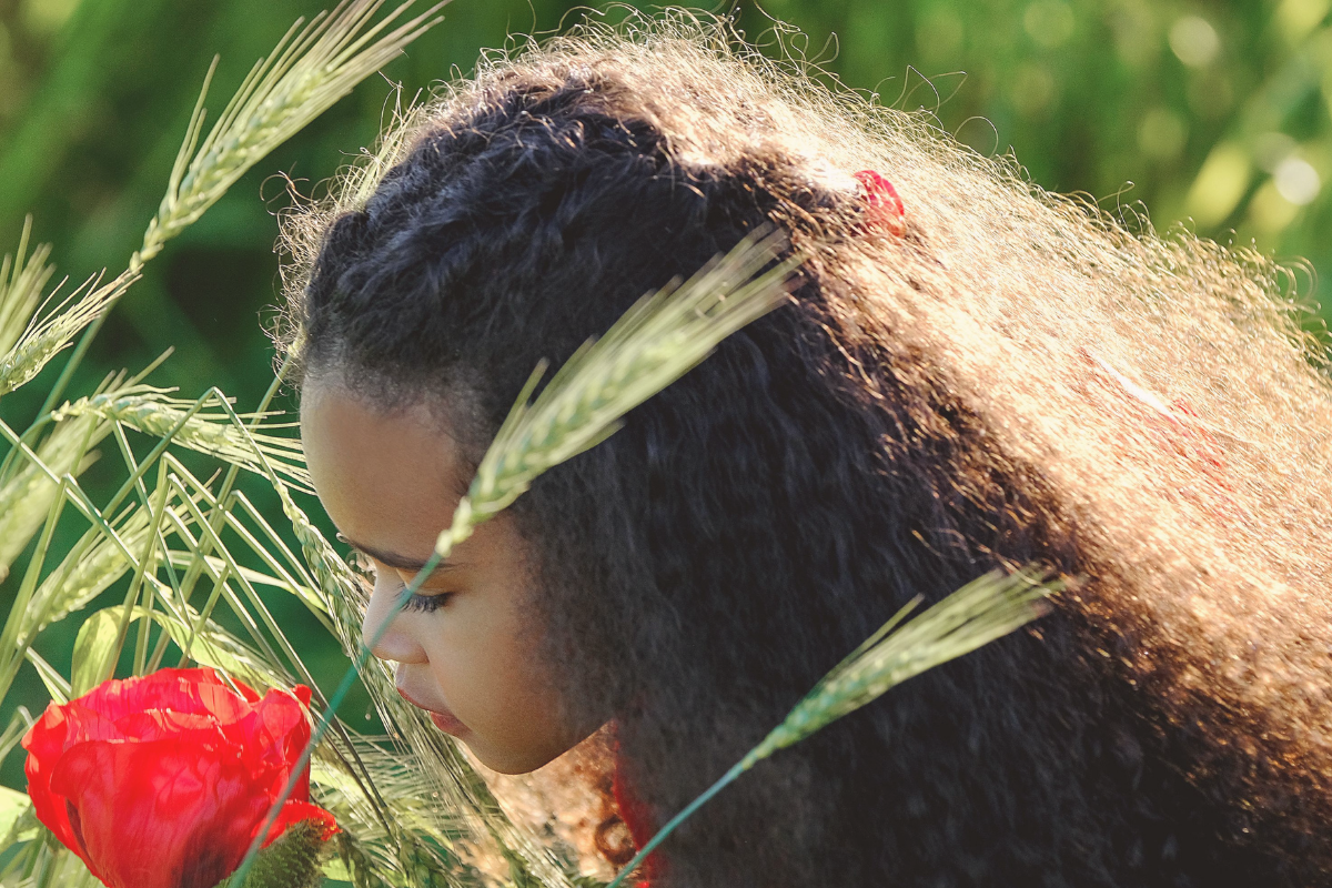 Bambina con capelli ricci lunghi e naturali all’aperto